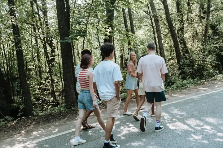 A Ranger leader mentoring young people on a forest path